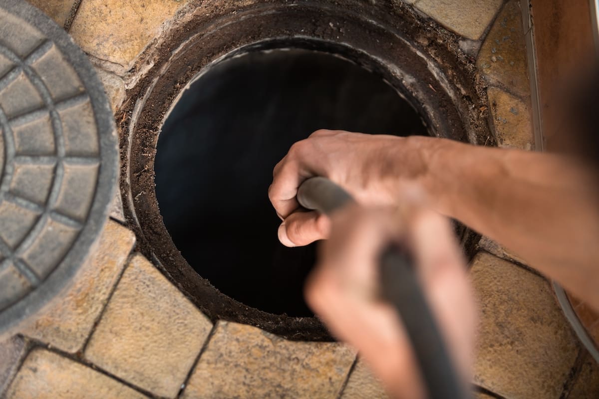 Technician hydro jetting a commercial kitchen drain